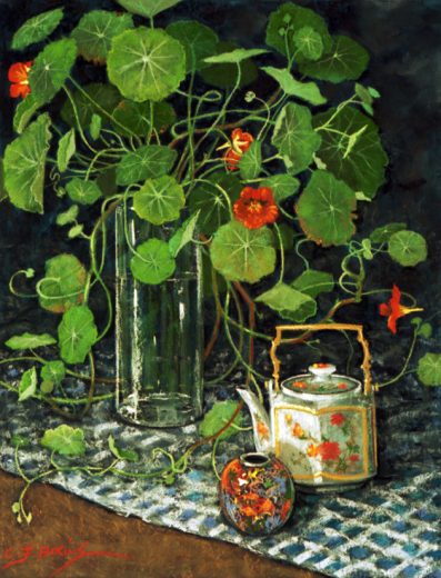 Nasturtiumss in a glass vase accompanied by a decorated teapot.