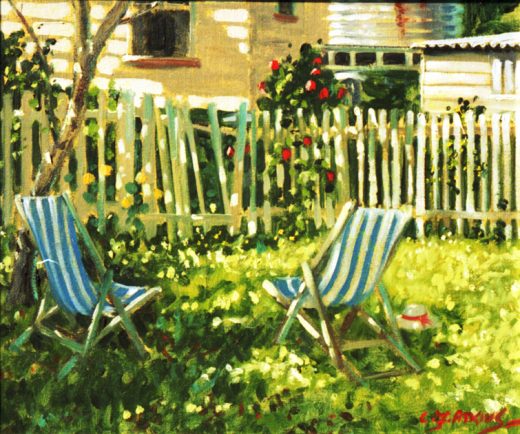 Two blue striped deckchairs in a backyard by a fence.