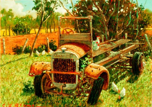 An old vehicle rusts away in a paddock. Chickens scratch for food in the nearby grass.