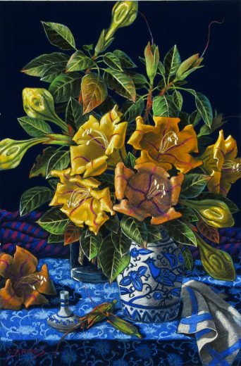 Bright yellow flowers are in a vase with a bright, blue, bird motif.