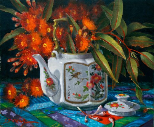 An old teapot , now used as a vase, contains orange gum blossoms.