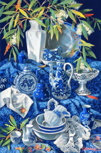 Blue and white pottery is arranged on a blue patterned cloth.