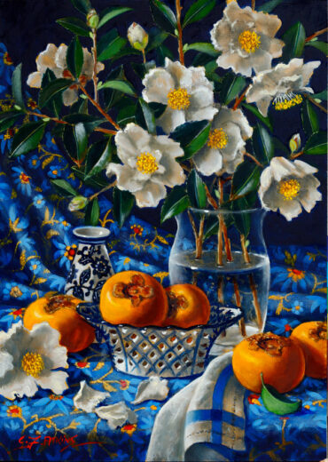 The white flowers are in a glass vase while the pomegranates are around the vase.