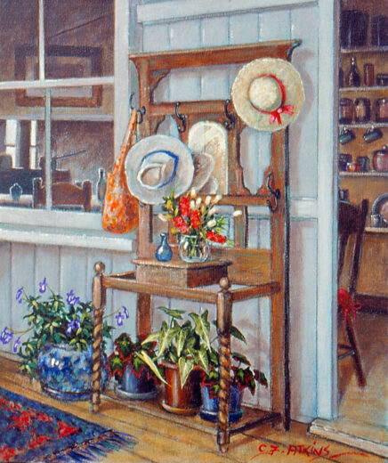 An antique hatstand, complete with potted plants, stands near the doorway to a kitchen.