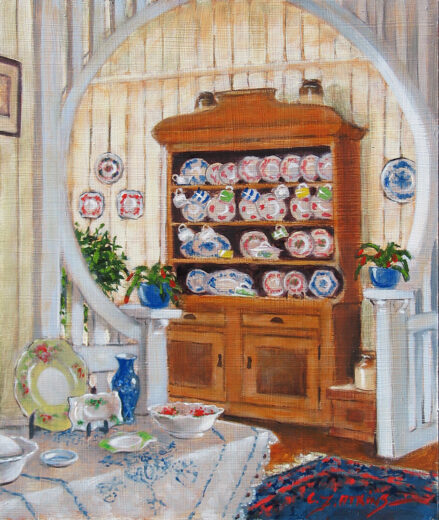 A cupboard with open shelves displays fancy chinaware.