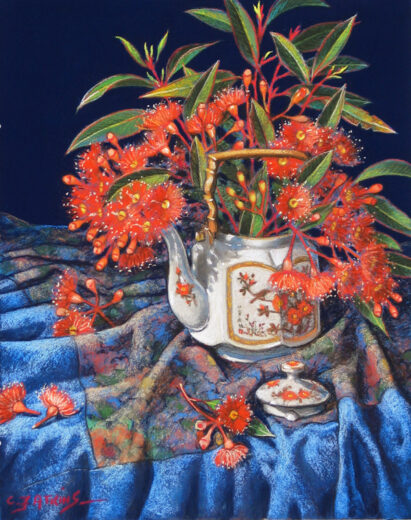 Orange eucalypt flowers are in an old decorated porcelain teapot. 