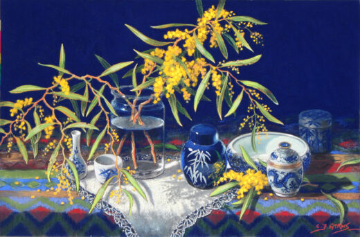 A vase of zig zag wattle flowers is accompanied by blue and white china.