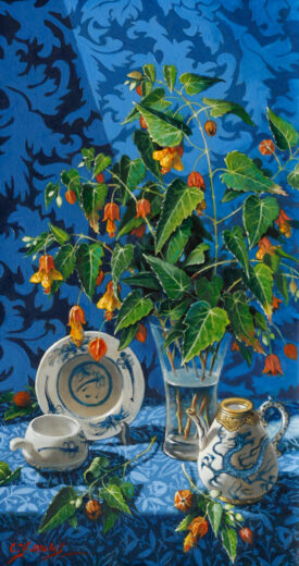 A teapot with a dragon decal is shown next to a vase of Chinese lantern flowers.