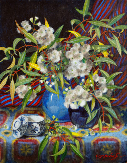 White eucalypt flowers in a blue jug.