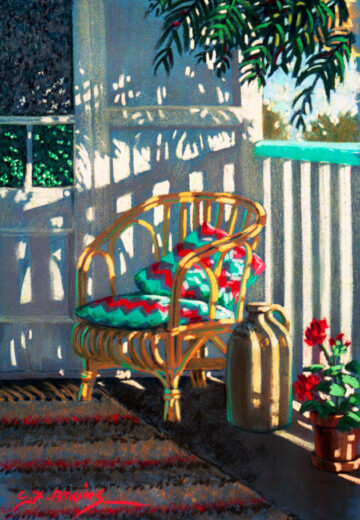 A cane chair with colourful cushions has shadows cast on it by the bright morning sun.