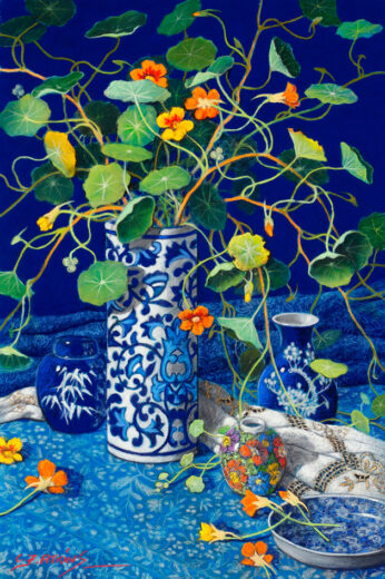 A tall vase of flowers is set against a blue background.
