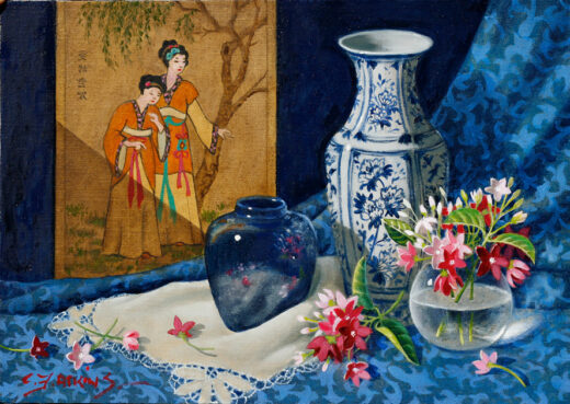 Rangoon creeper flowers rest on a patterned cloth accompanied by Asian-themed objects.