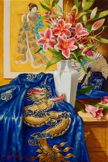 A vase of lilies is shown accompanied by a fan and also a wall hanging with an oriental theme.
