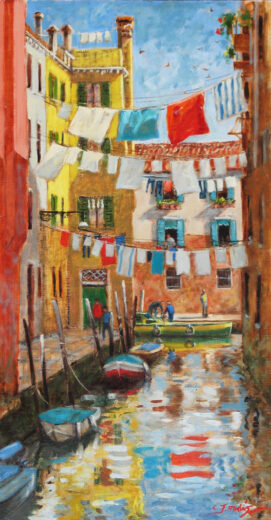 Many lots of washing are strung on lines across the canal.