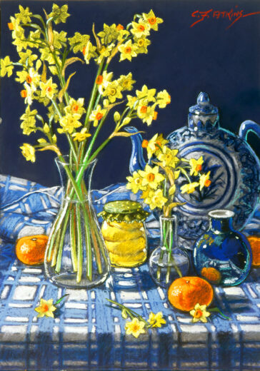 A glass vase of jonquils stands on a blue and white tablecloth. Brightly coloured fruit and an oriental- style teapot complete the scene.